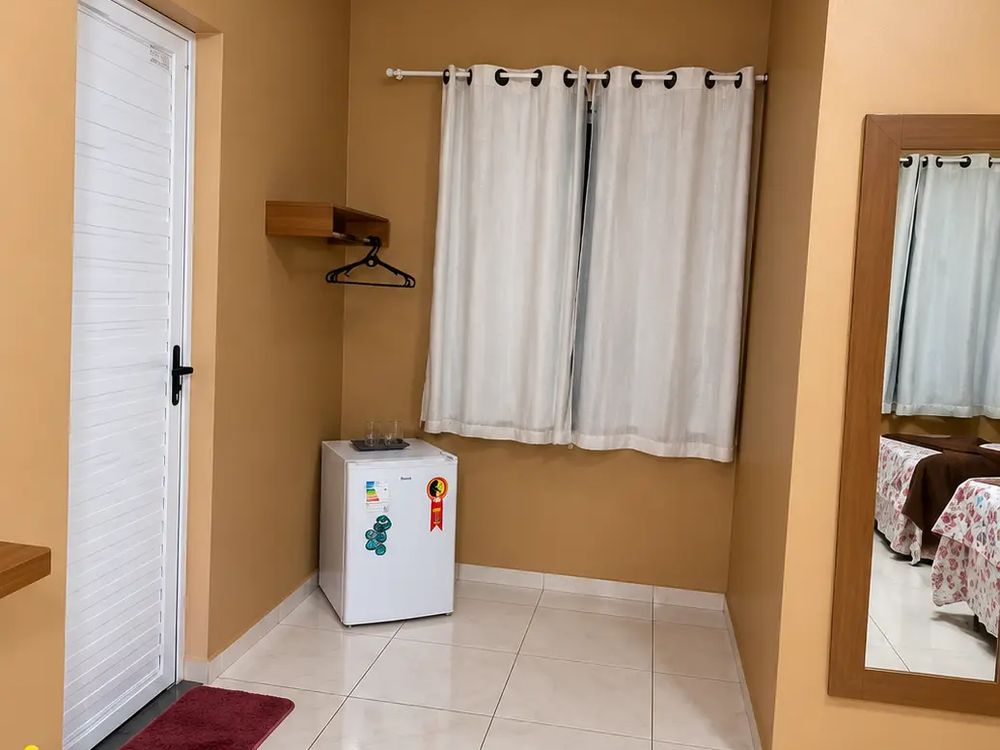 Quarto com espelho e frigobar